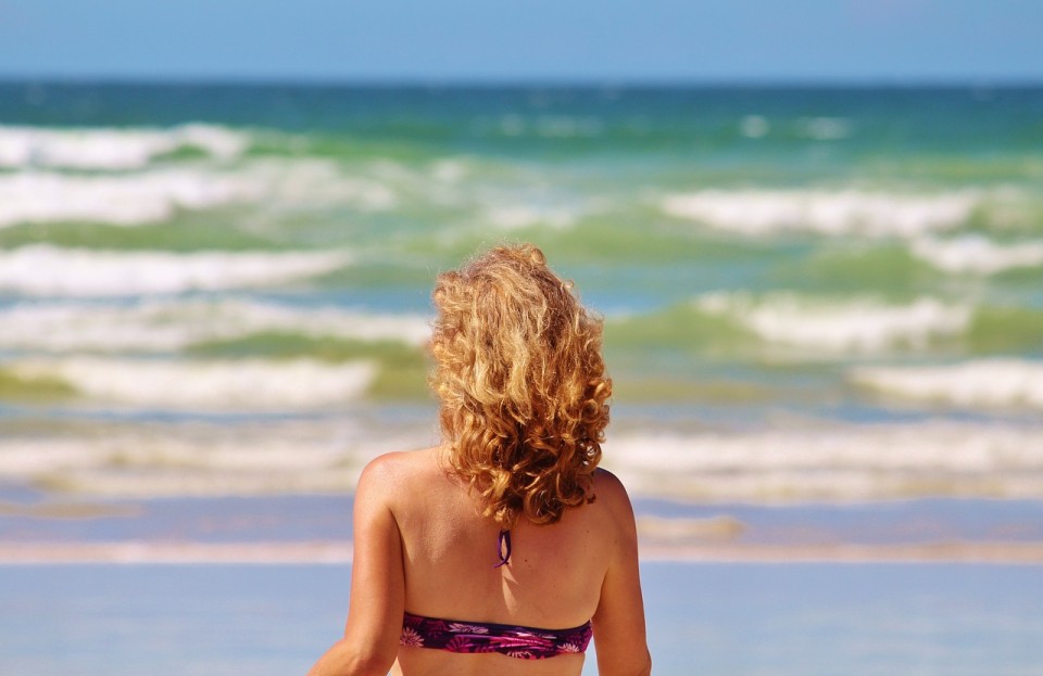 Aceites vegetales para la piel, mujer rubia en la playa, notas naturales