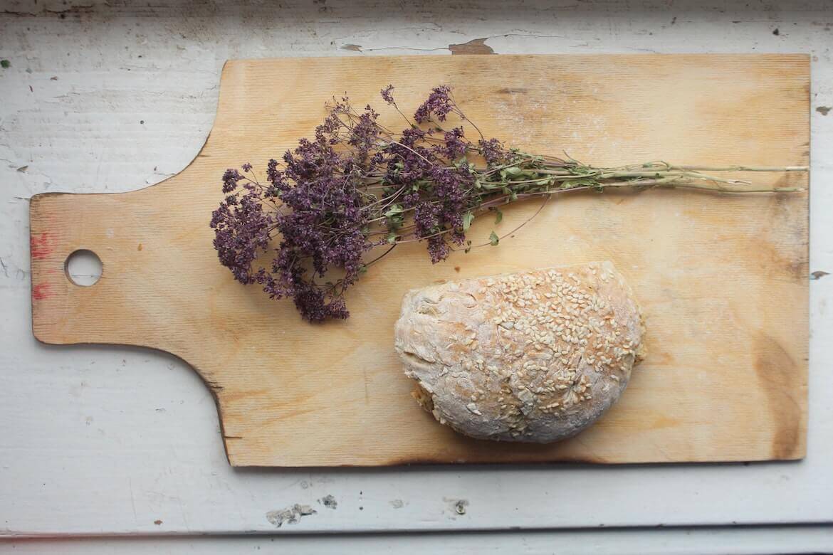 Tabla de madera con pan y hierbas aromáticas secas