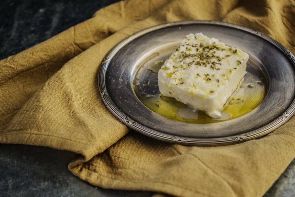 Plato con queso fresco aliñado con aceite de oliva y hierbas aromáticas como orégano