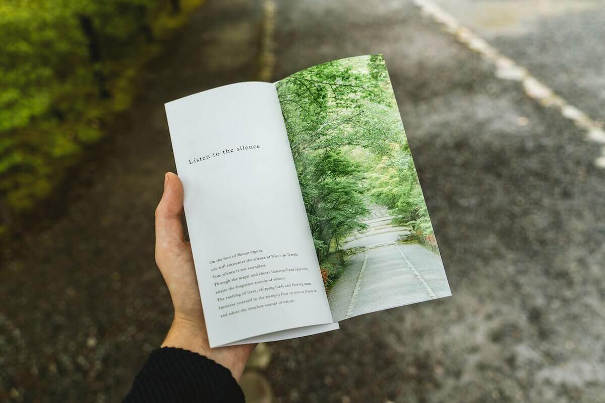 mano de un hombre sujeta un libro sobre naturaleza